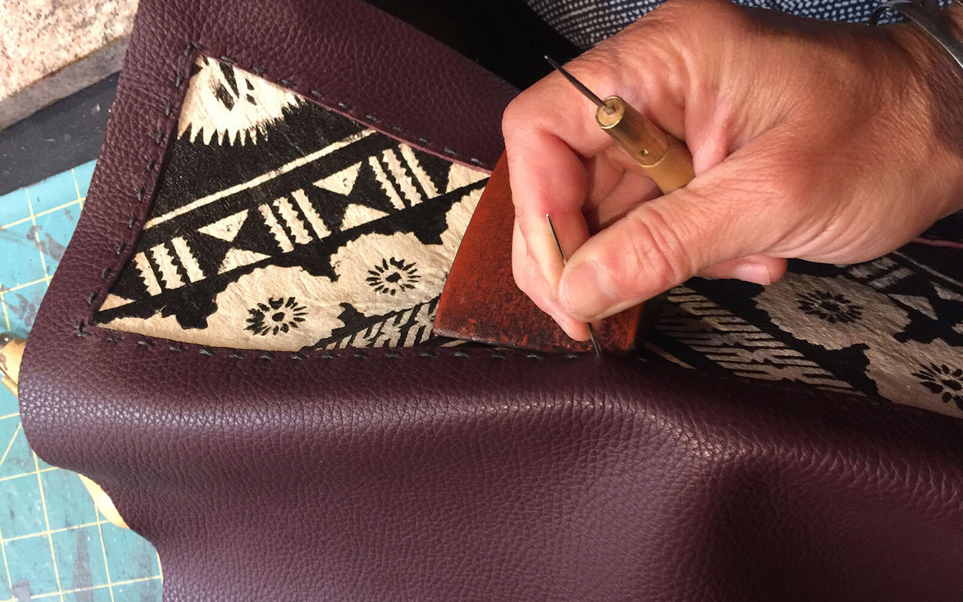 Hand stitching Fijian tapa cloth to leather.  Tote made by Bottega Flaviani handmade leather handbags and accessories brand in San Francisco